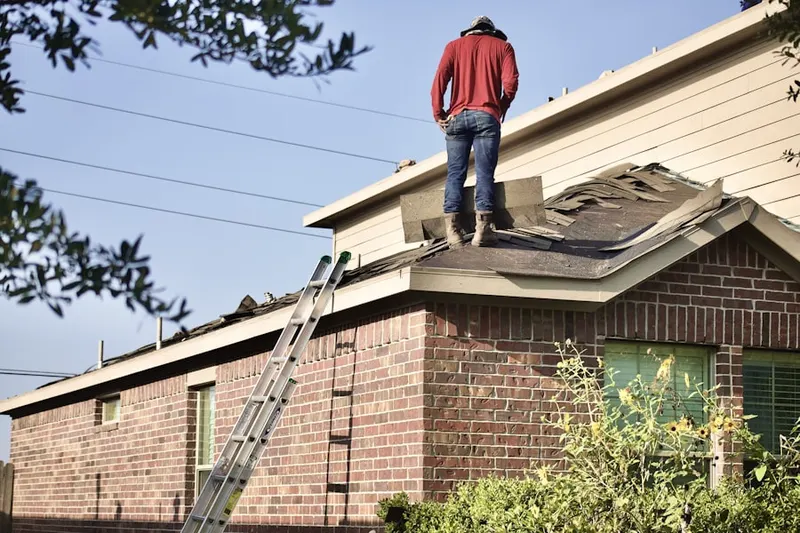 Professional roofer working on a residential roof in West Foxboro